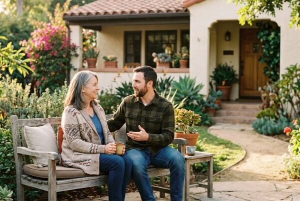Mother and adult son talking on a bench outside a San Diego home